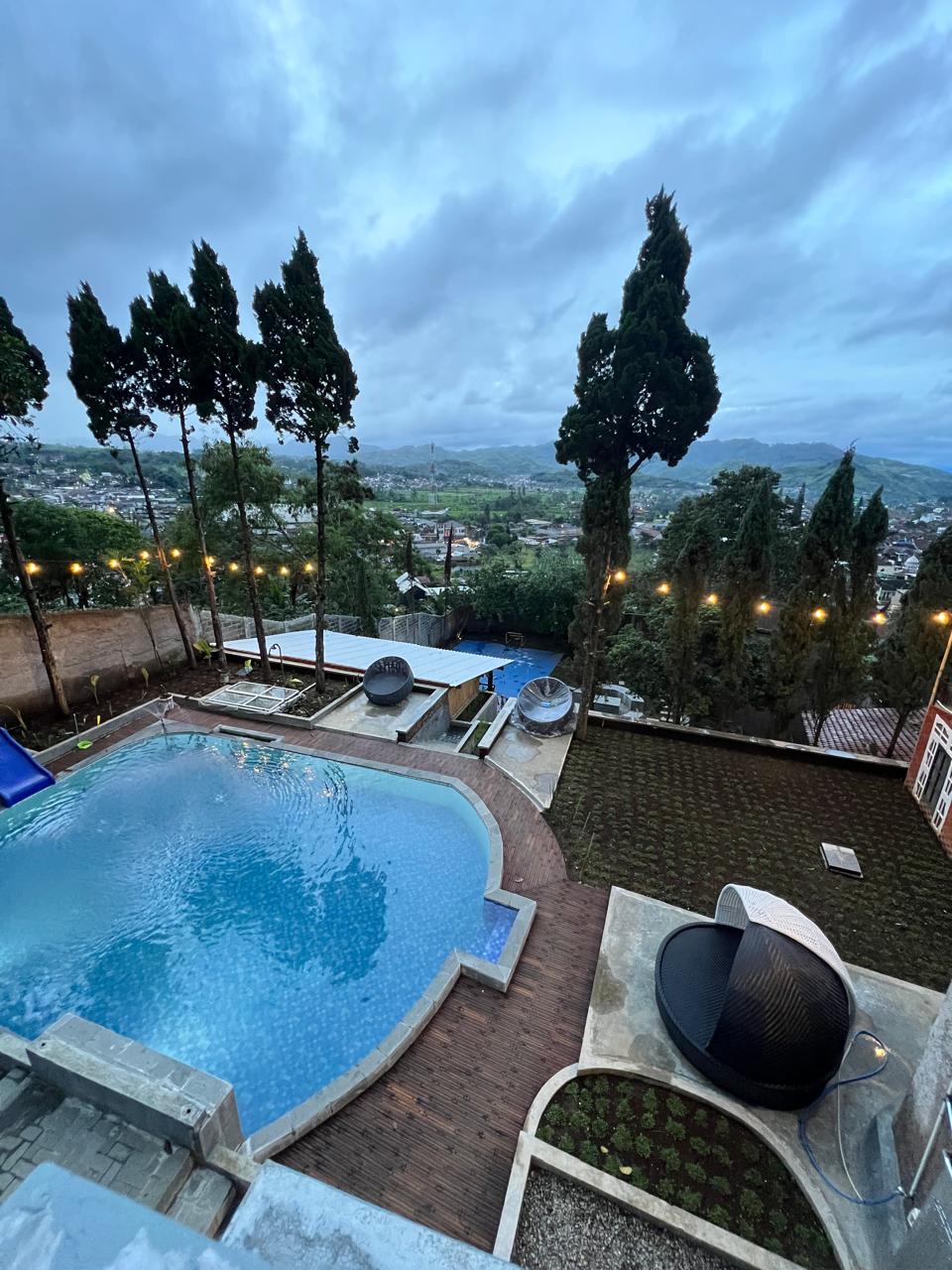 Kolam renang Villa Kaki Bukit Ciwidey dengan pemandangan perbukitan