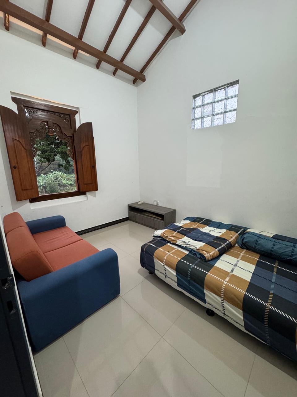 Kamar dengan sofa dan view kebun