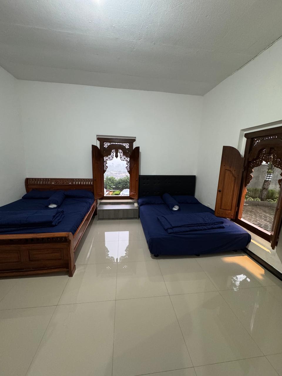 Kamar dengan dua bed queen dan jendela ukir